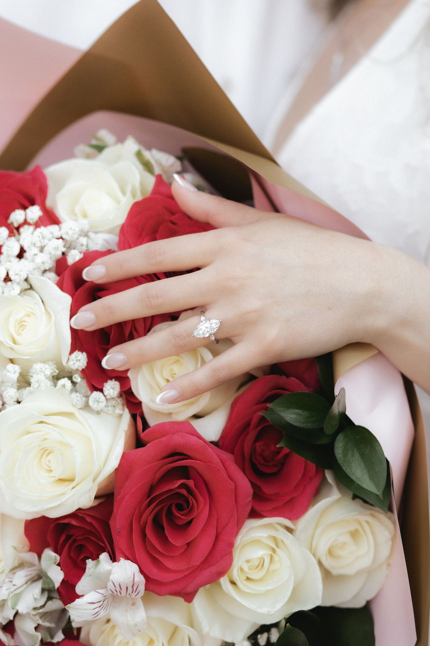 Newlywed engaged couple showing engagement ring on bouquet of roses after proposal in The Ancient Spanish Monastery, Miami Beach