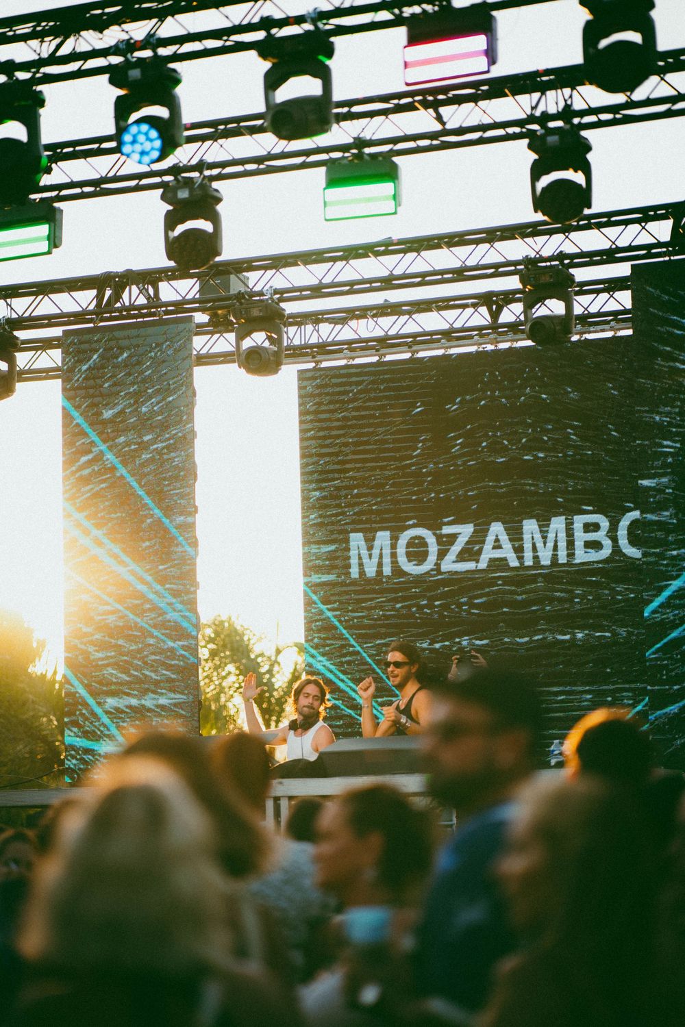 Scène du festival de musique en plein air avec  MOZAMBO, éclairage de la scène et la foule profitant d'une performance au coucher du soleil