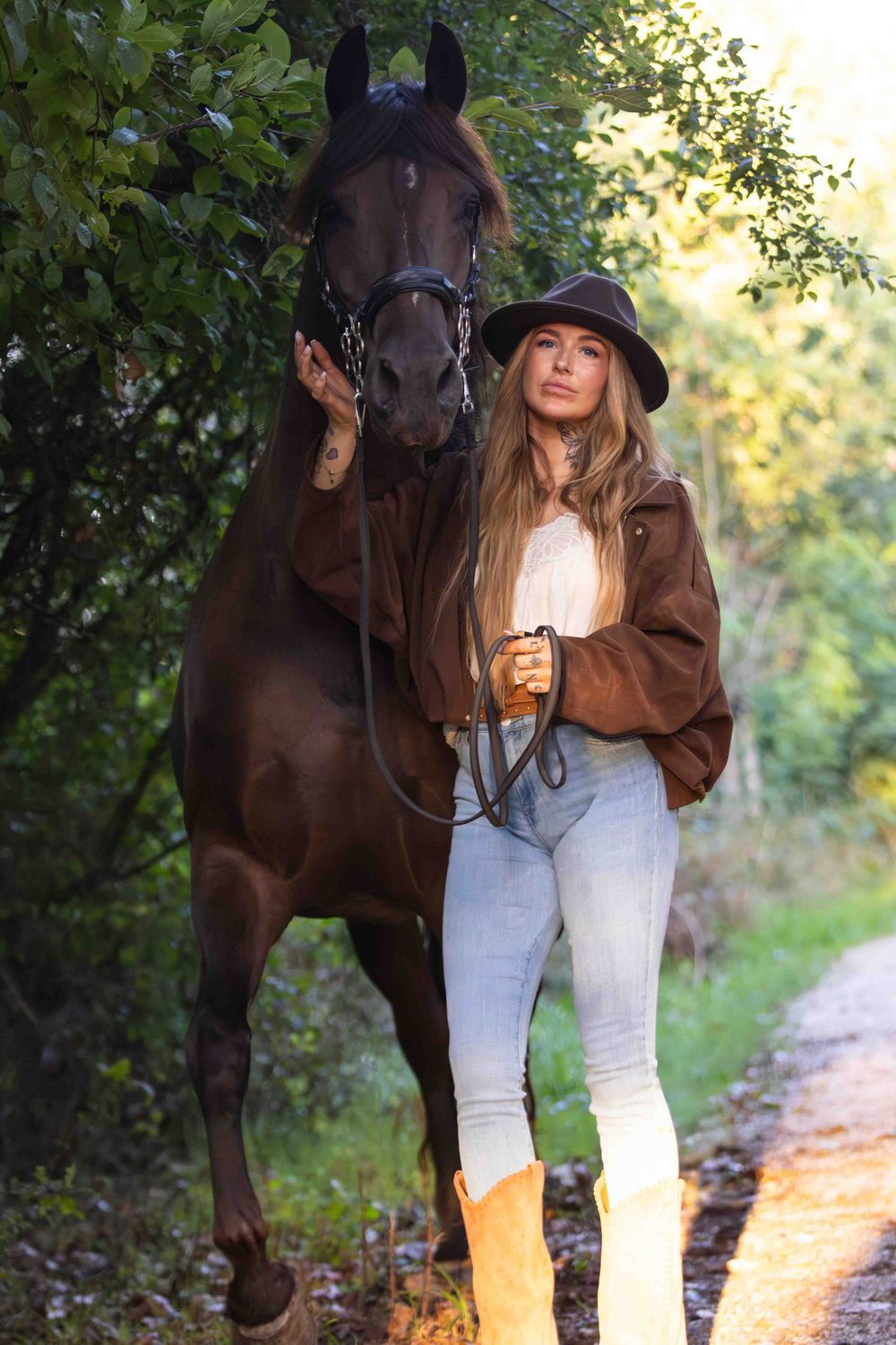 meisje met hoed op en zwart paard