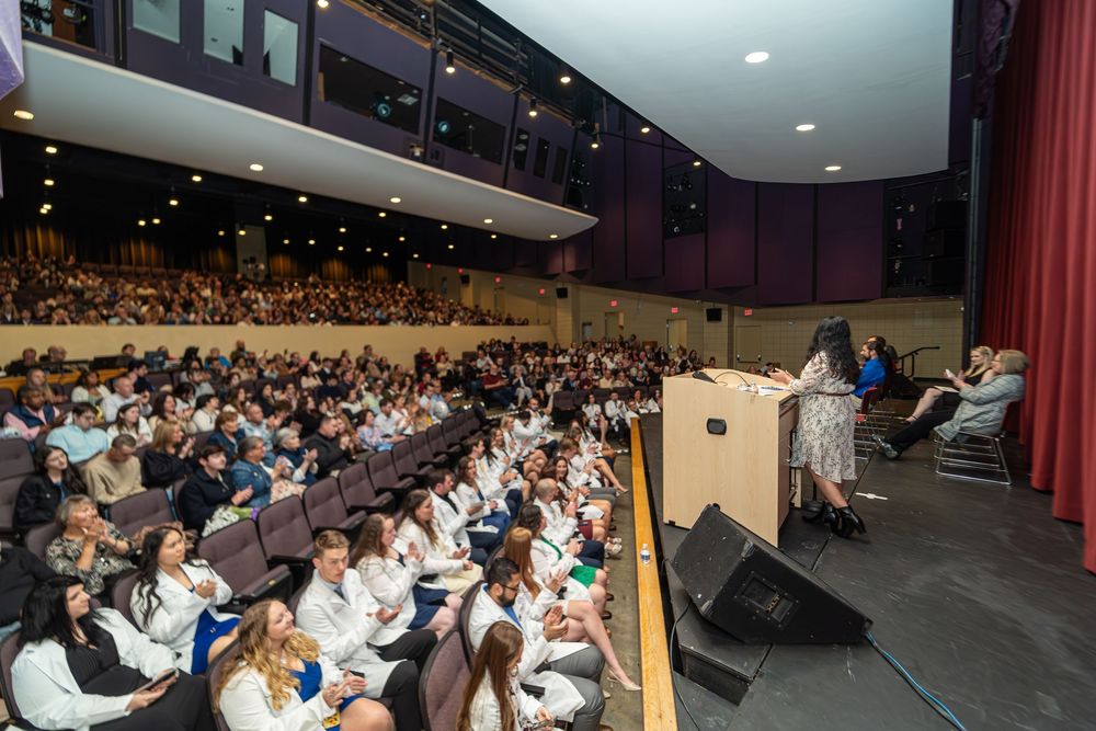 A panoramic view of a packed auditorium with rows of seated attendees during an event.