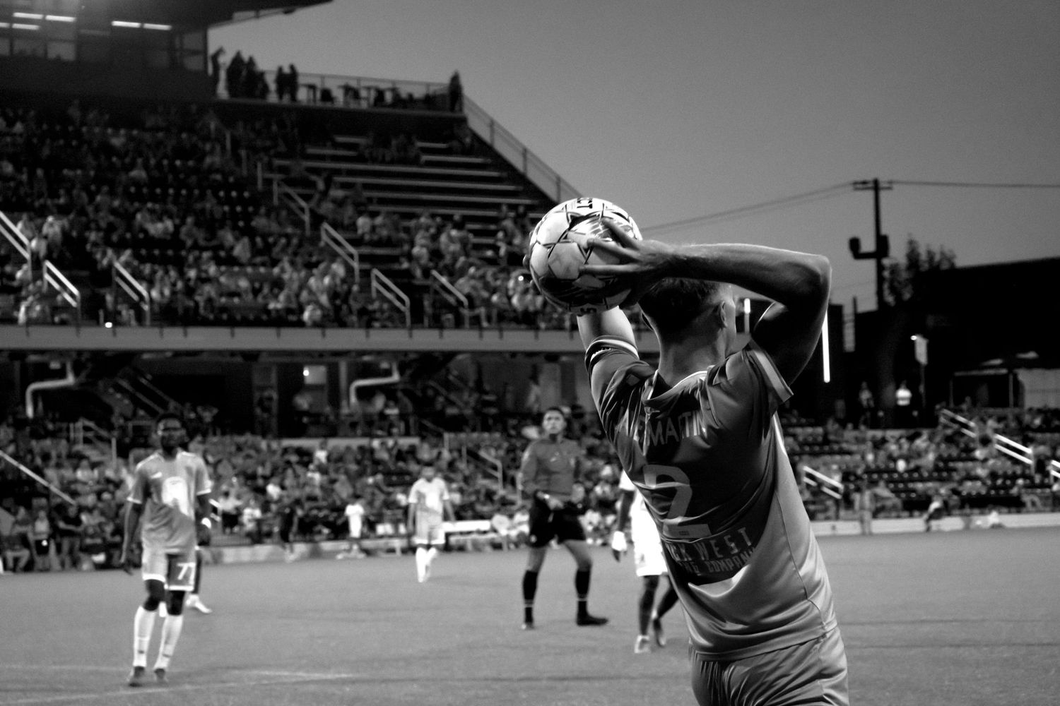 A sequence of black and white sports action shots showing athletes competing in what appears to be a soccer match.