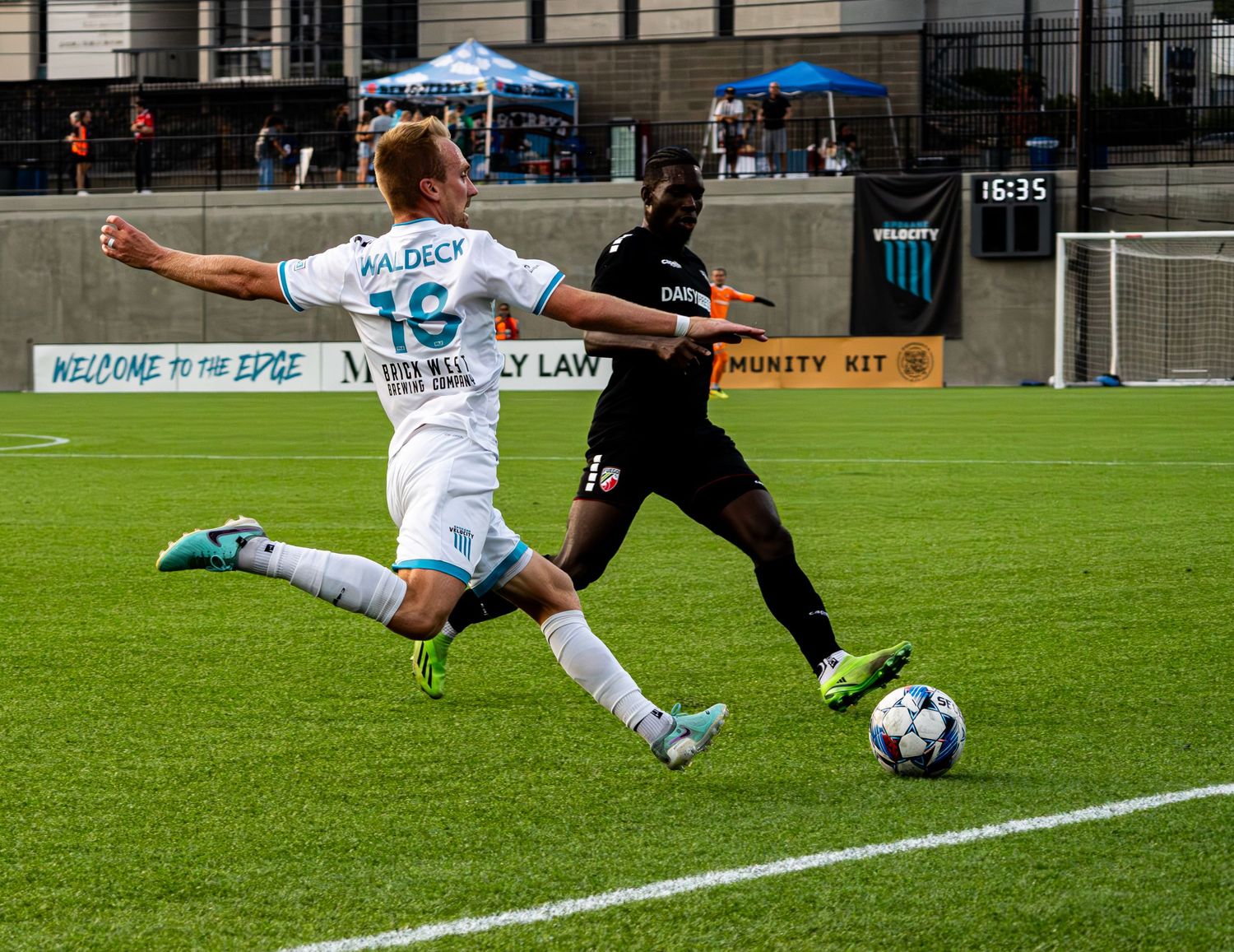 Soccer players from opposing teams battle for possession of the ball during a competitive match on the field.