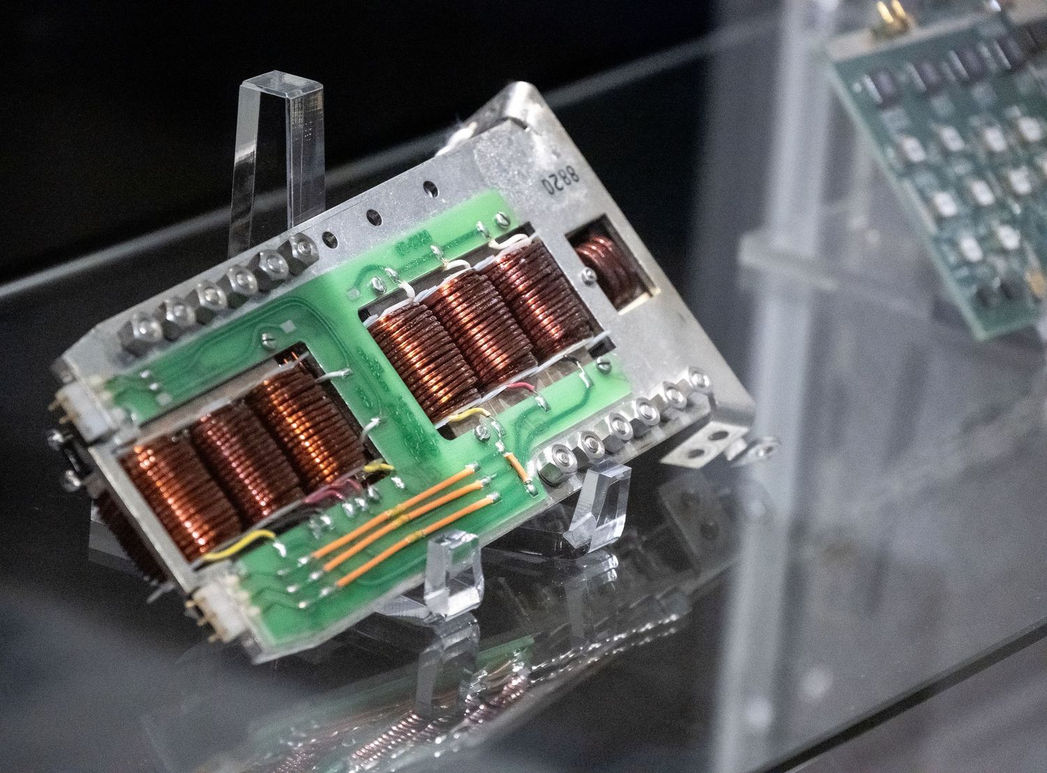 Close-up of vintage electronic circuit board components with green PCB and copper connections.