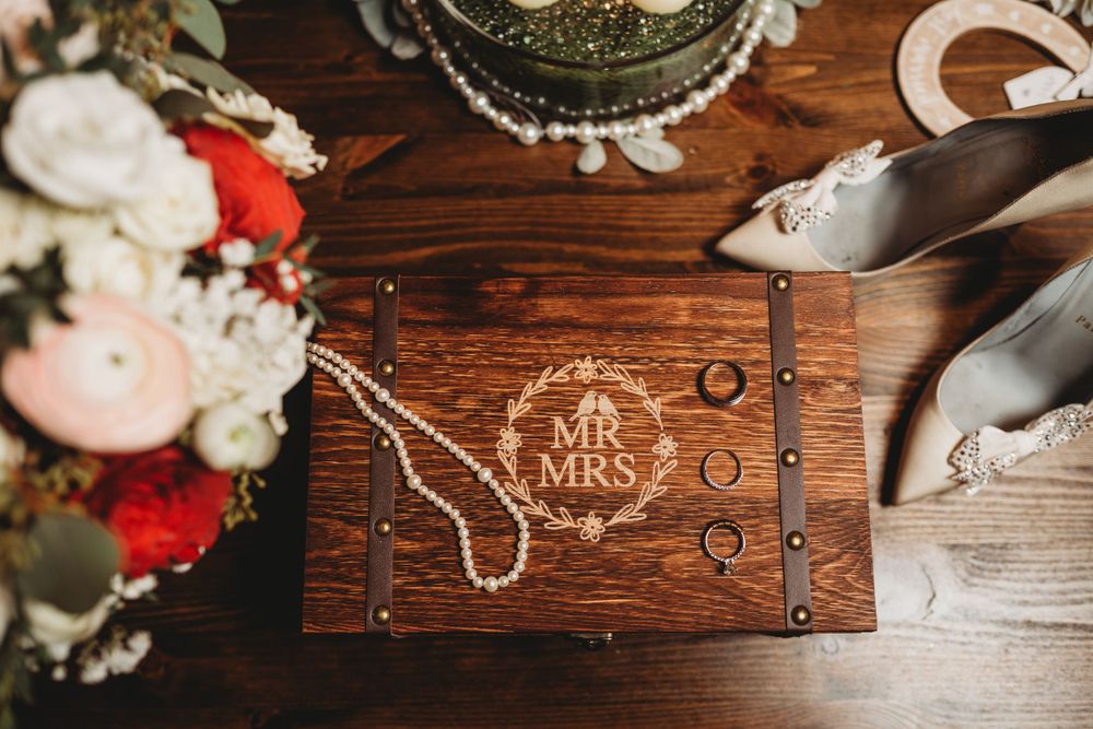 Rustic wooden box with Mr & Mrs engraving alongside wedding accessories.