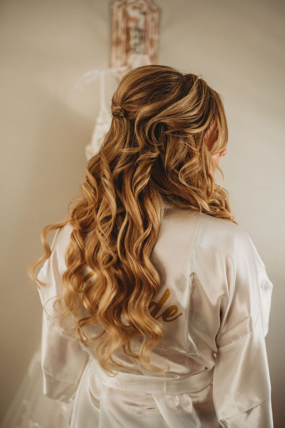 Elegant wavy blonde bridal hairstyle shown from behind.