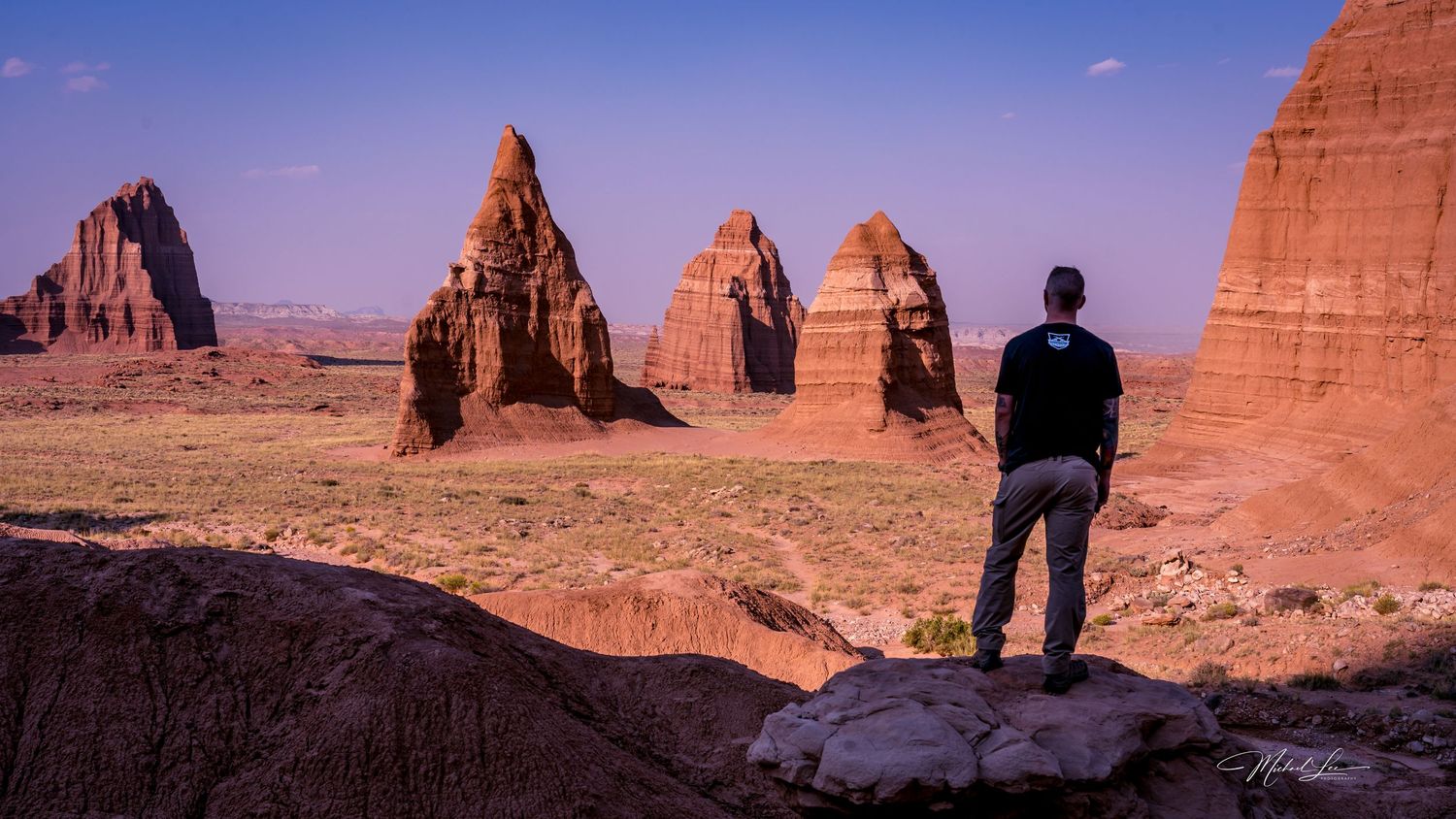 Scenic view of towering red rock formations in Utah's desert landscape under purple sky.