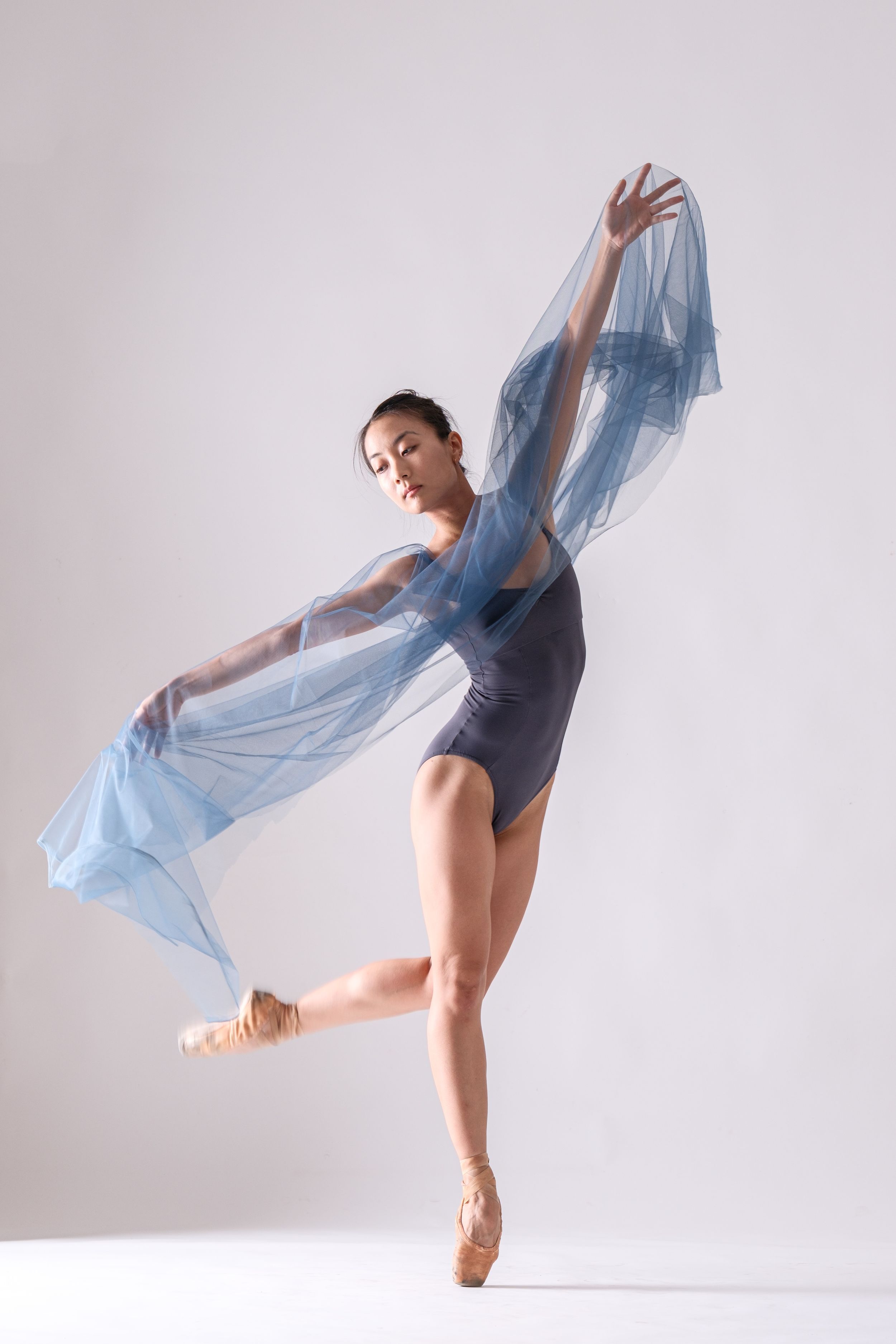 Modern dance sequence with flowing blue fabric captured in artistic studio photography.