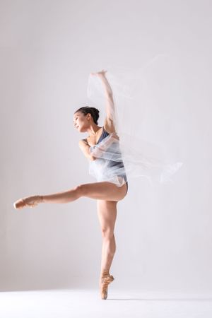 Graceful ballet movements captured in sequence with flowing white fabric and pointe shoes.