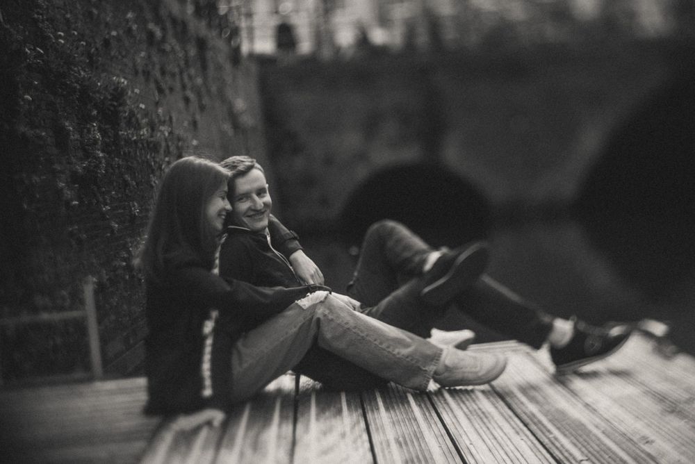 Black and white image of boots on wooden deck or boardwalk.