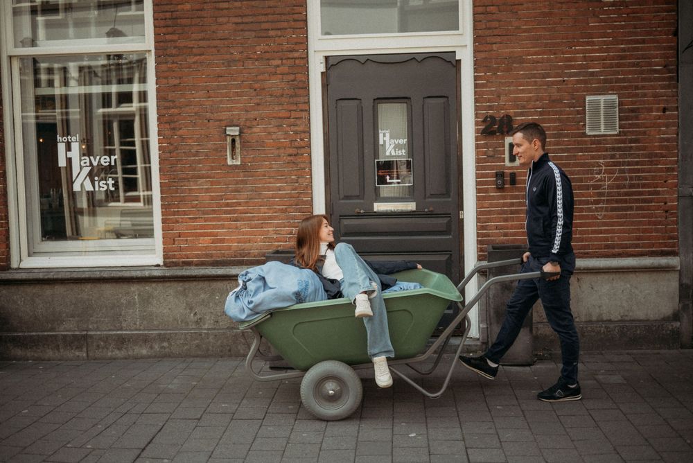 A couple walks together on a street lined with classic brick buildings.