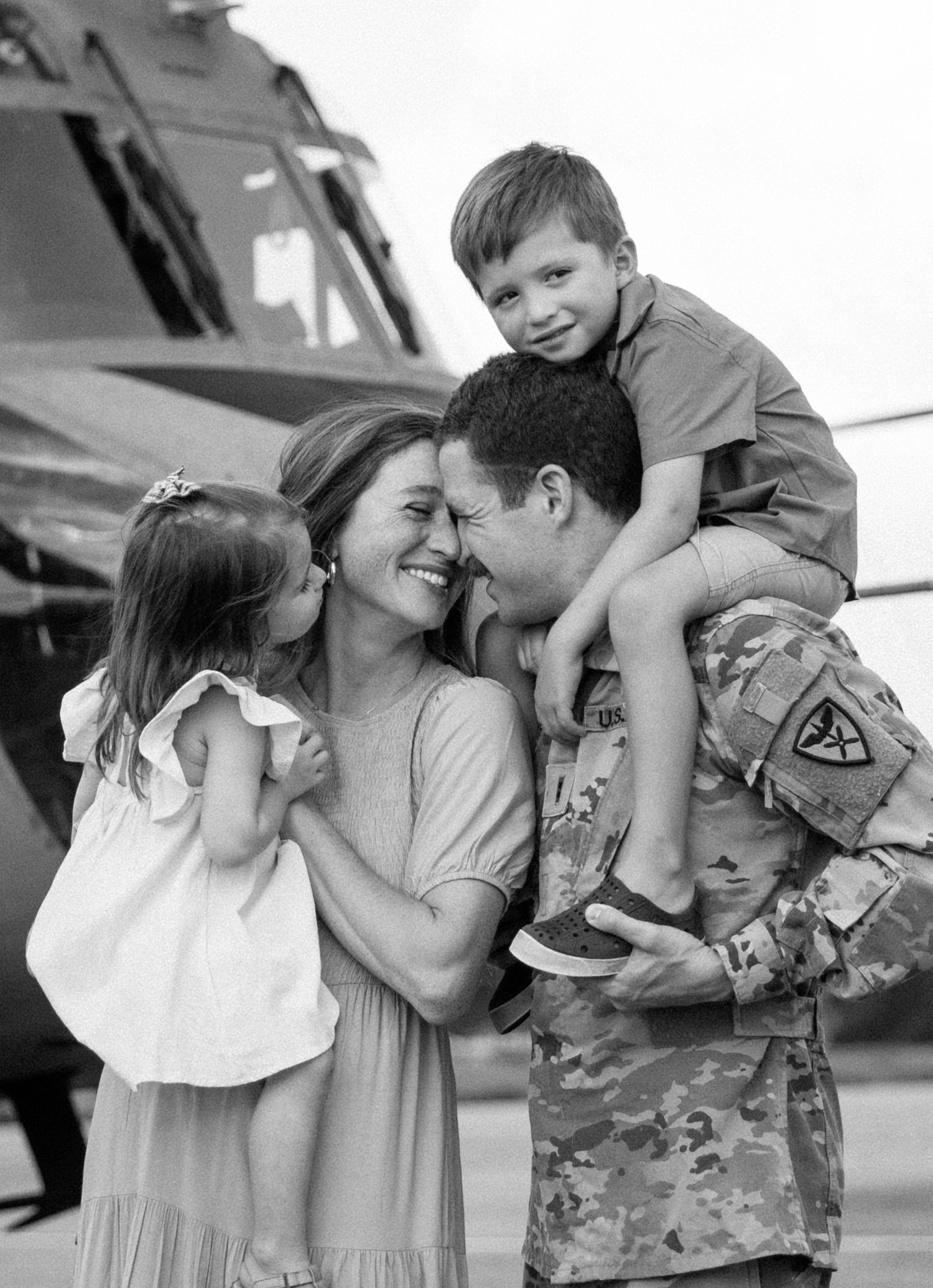 military family session A series of black and white photos showing emotional reunions between a military service member and family members.