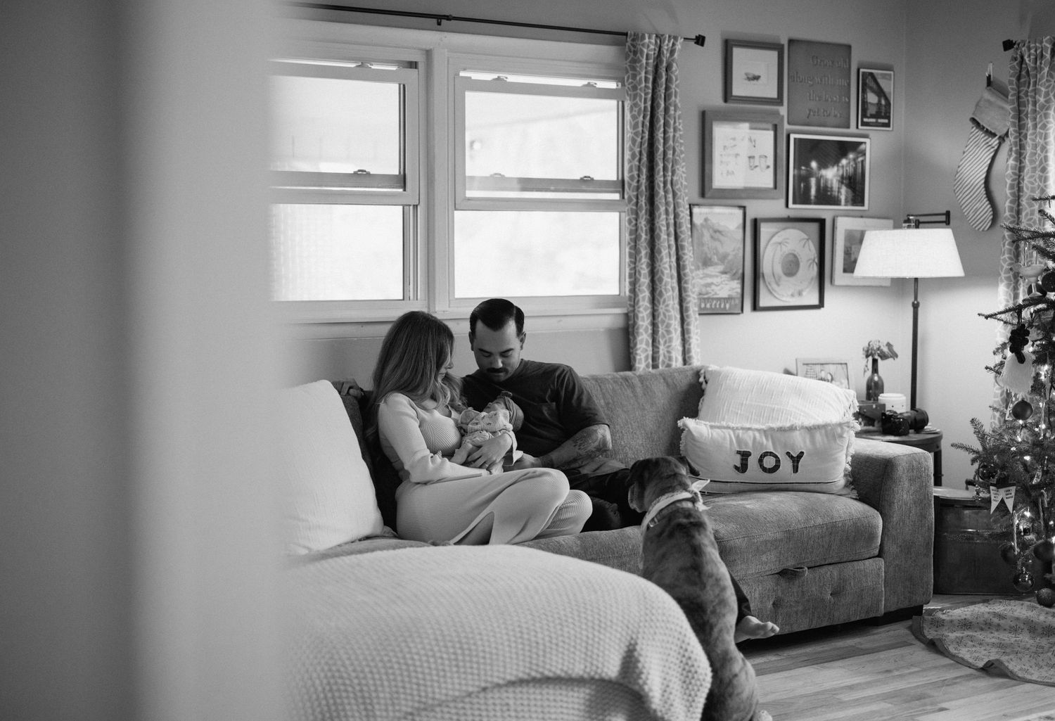 At home newborn session. Black and white photo series showing tender moments between couple with their newborn in intimate home settings.