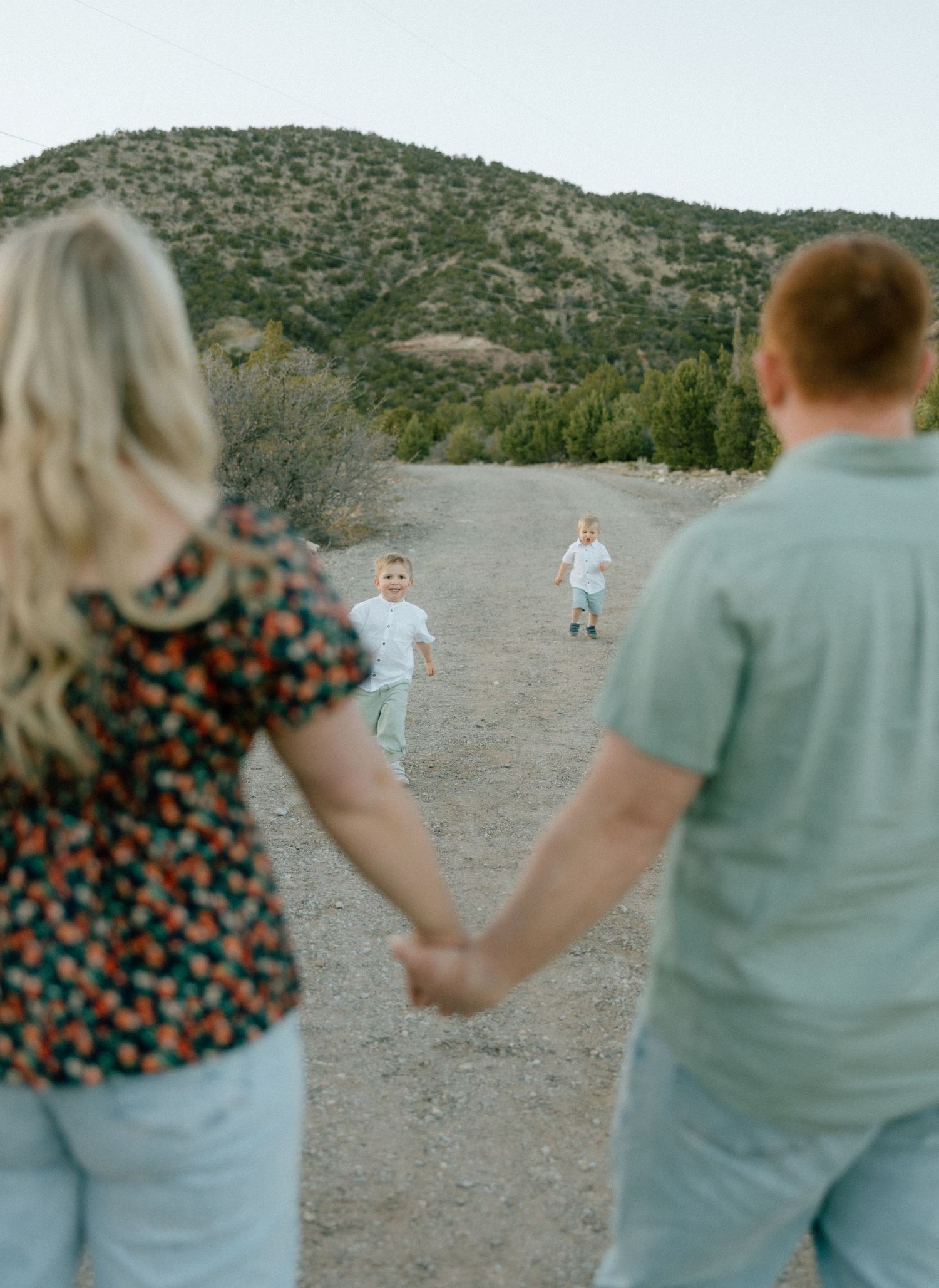 A series of motion shots showing people holding hands and spinning in a desert landscape with mountains in the background.