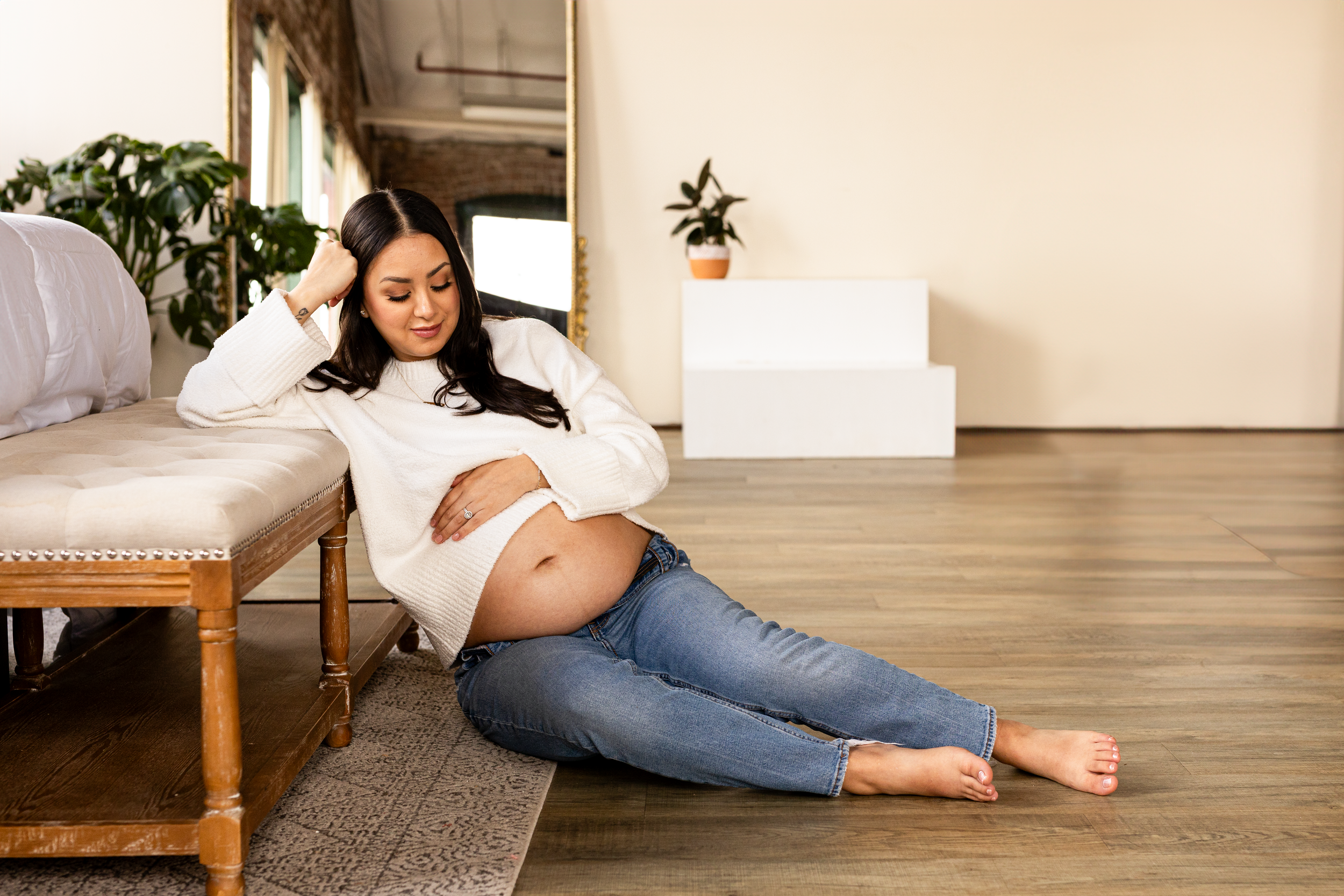 A relaxed maternity photo featuring a woman reclining on a chaise lounge.