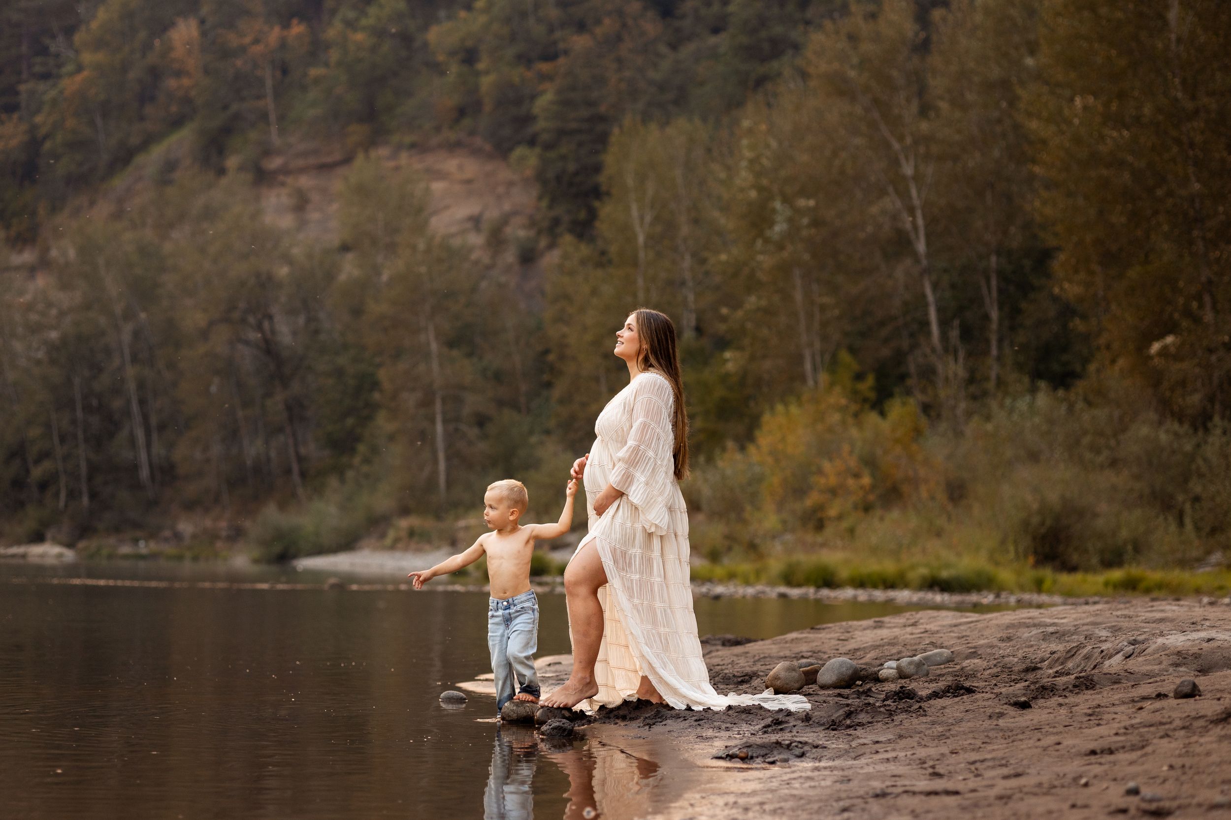A serene moment captured at a riverside with autumn foliage in the background.