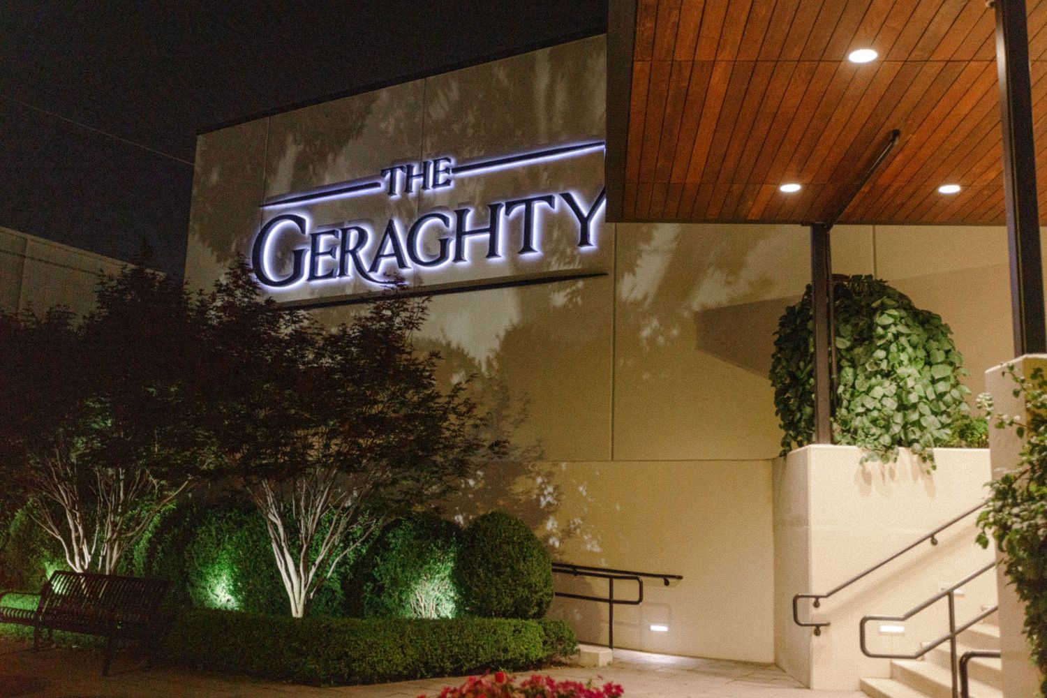 Illuminated exterior signage of The Geraghty venue at night.