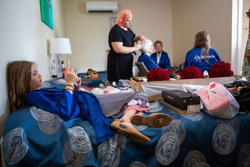 People in matching blue sweatshirts sit around a table during an activity.
