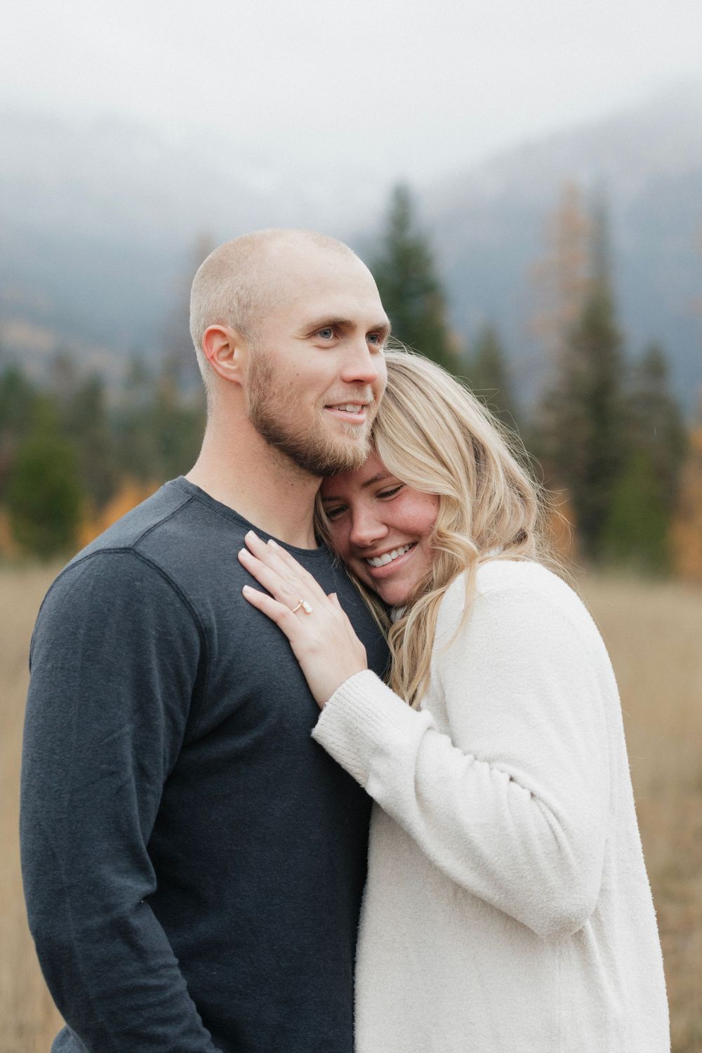 Joyful couple sharing intimate moment in autumn mountain setting.