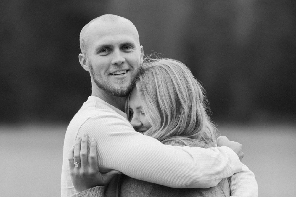 Black and white portrait of couple embracing outdoors.