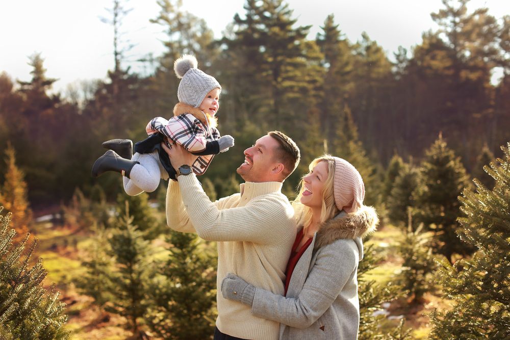 Family in a tree farm all wearing sweaters and hats in Wells Maine South Berwick maine
