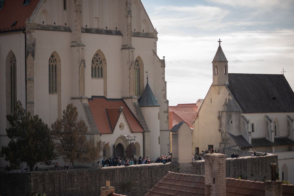 Gothic church architecture with white walls and spires against cloudy sky.
