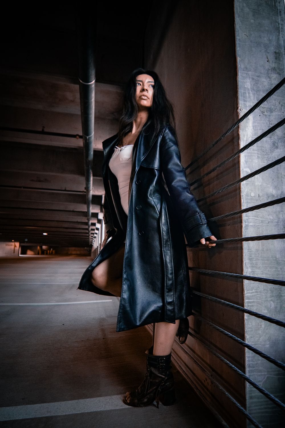 Artistic sequence of dark moody photos showing someone in a black leather jacket against concrete walls in a dimly lit hallway.