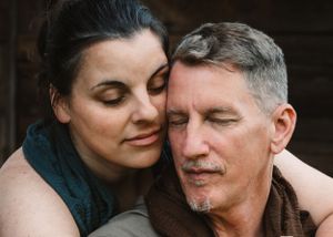 Romantic couple with closed eyes resting foreheads together in a tender embrace.