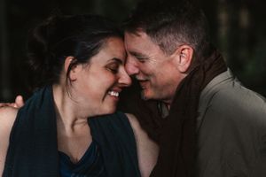 Smiling couple sharing a joyful, intimate moment with foreheads nearly touching.