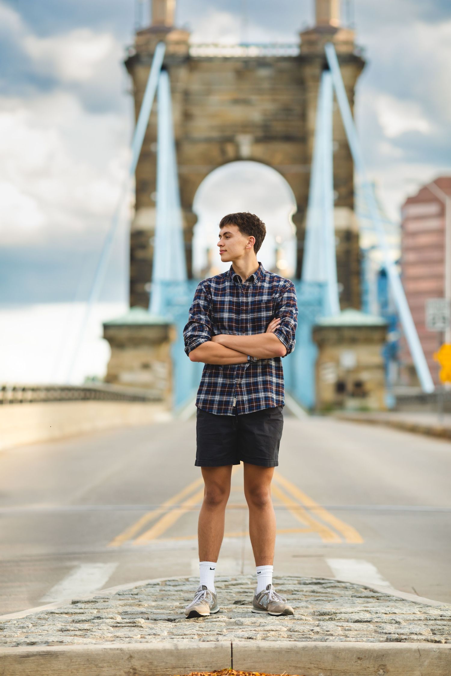 Guy looking away in front of the Roebling bridge during senior photos