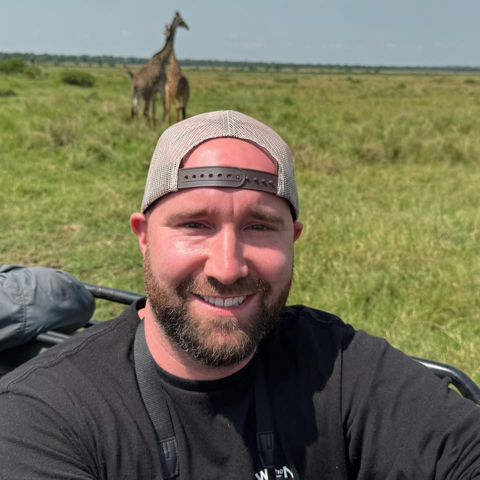 Safari selfie with giraffes grazing in African savanna background.
