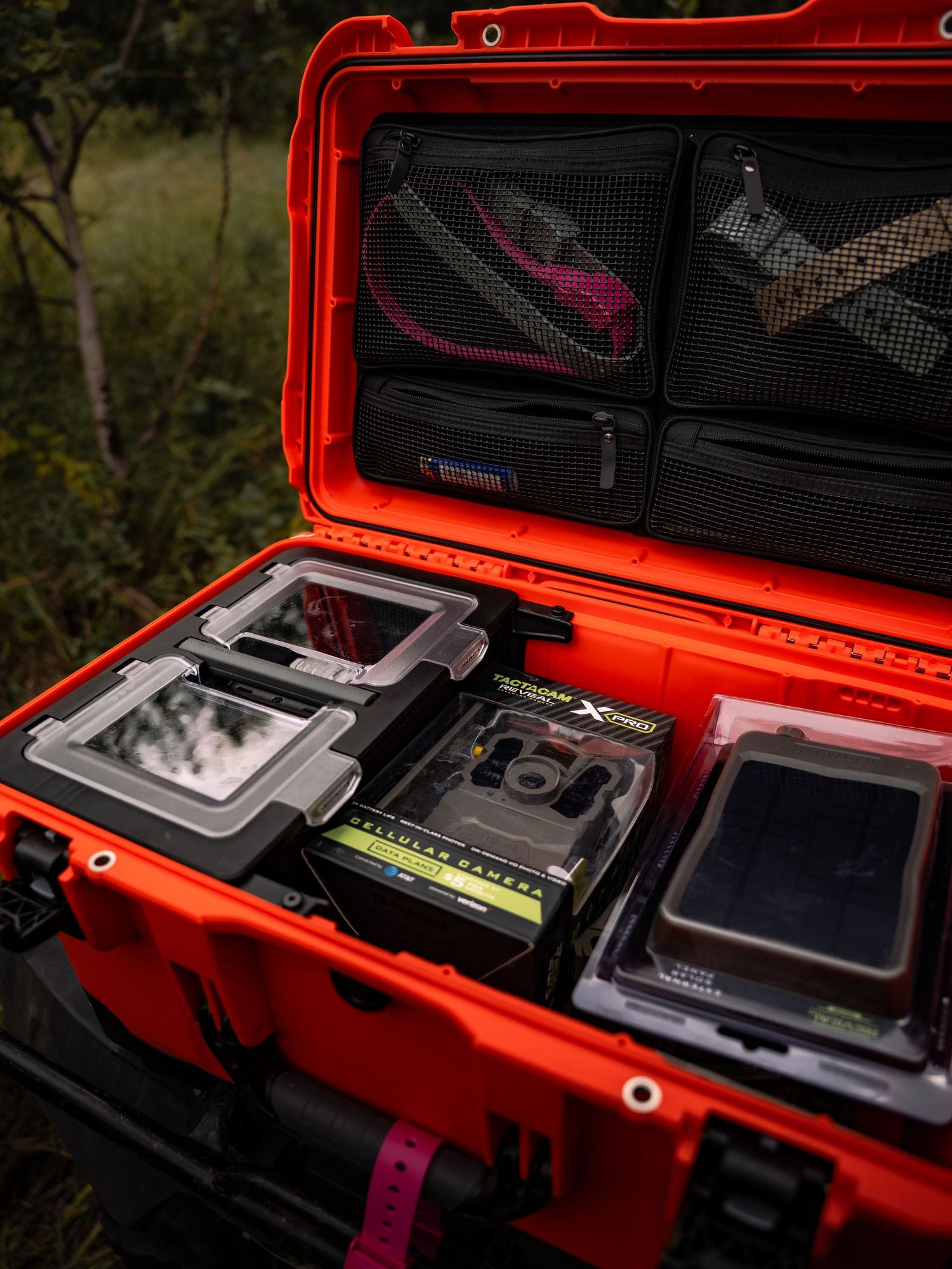 Orange protective case filled with camera equipment and accessories.