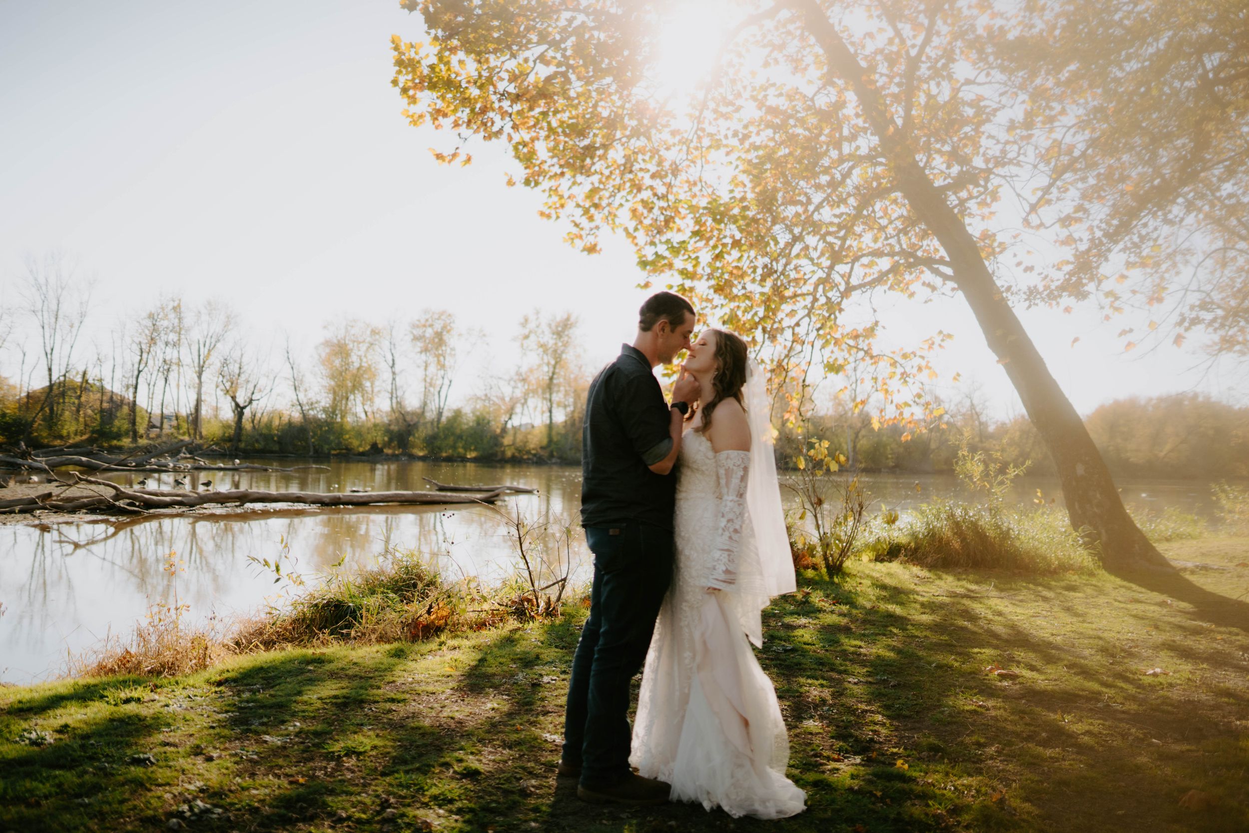 Romantic wedding photos captured in golden sunlight with fall foliage backdrop.