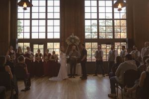 Wedding ceremony venue with large windows and natural light streaming in.