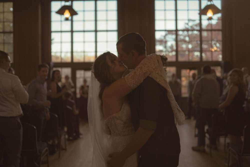 Couples dancing together during wedding reception in elegant venue with large windows.