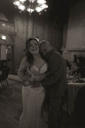 A joyful moment shared between dancing partners at an indoor reception venue.