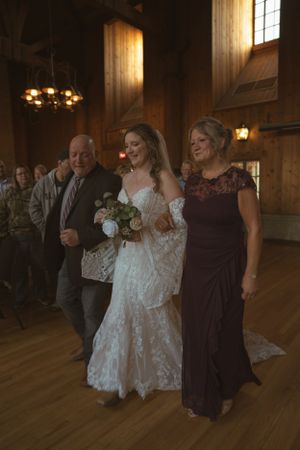 Wedding celebration inside rustic wooden venue with warm lighting and hardwood floors.