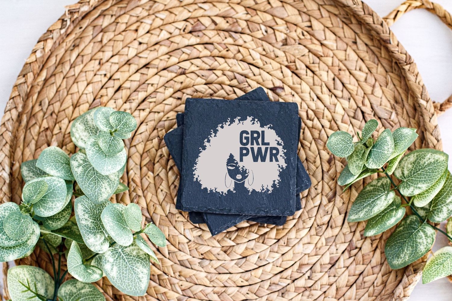Navy blue card with text design displayed on woven rattan placemat with artificial greenery.
