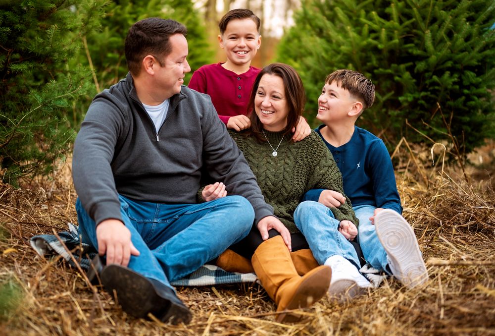 Candid family portrait session showing joyful interactions in a wooded area.