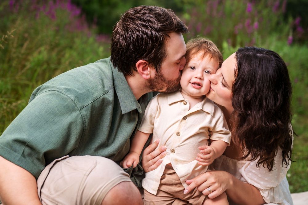 Family sharing tender moments together during outdoor photo session.