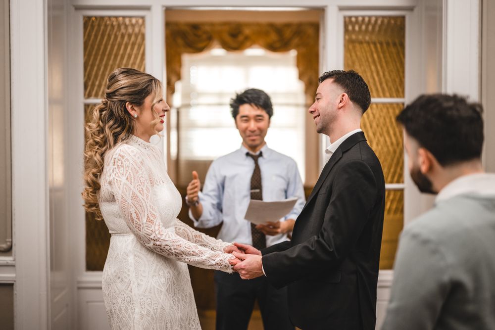 A couple shares an intimate dance moment in an elegant room with curtains and decorative molding.