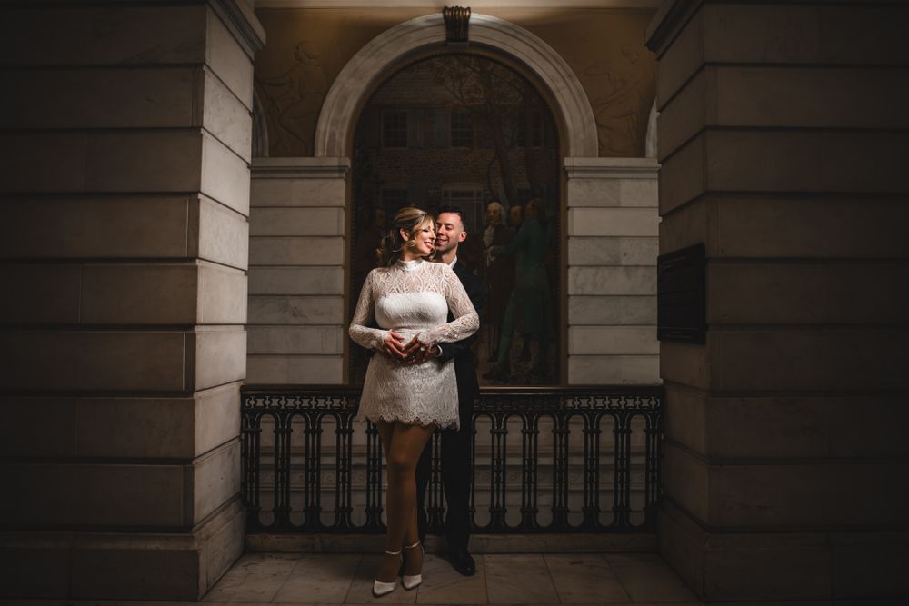 Romantic portraits captured in a dimly lit classical architectural setting.