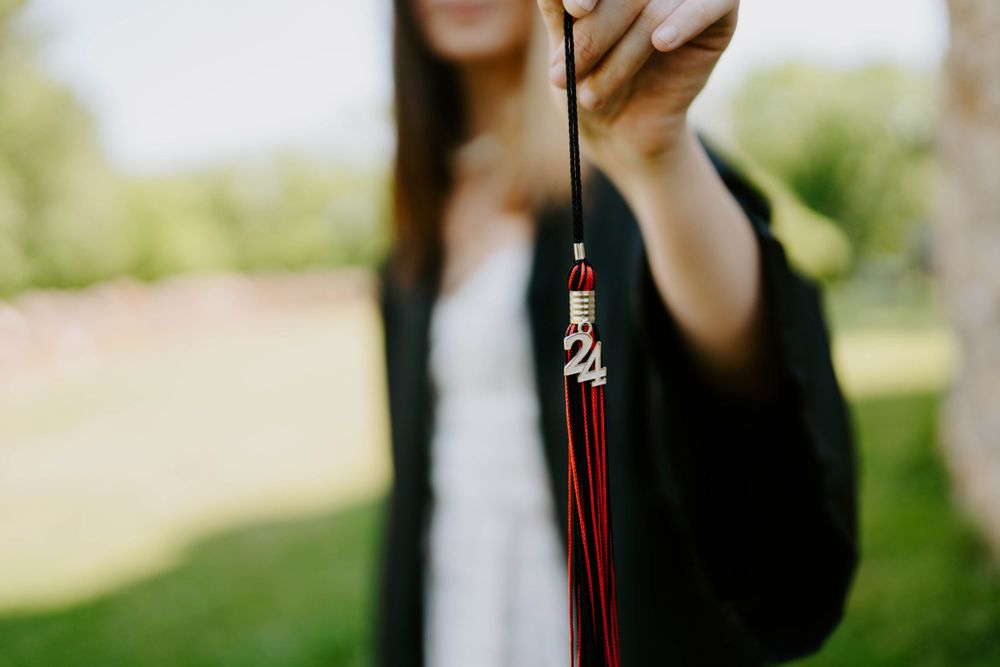 Close-up graduation photo showing black cap with red tassel.