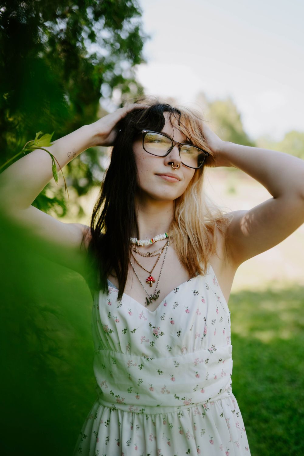 Artistic portrait series in white floral dress with natural garden backdrop.