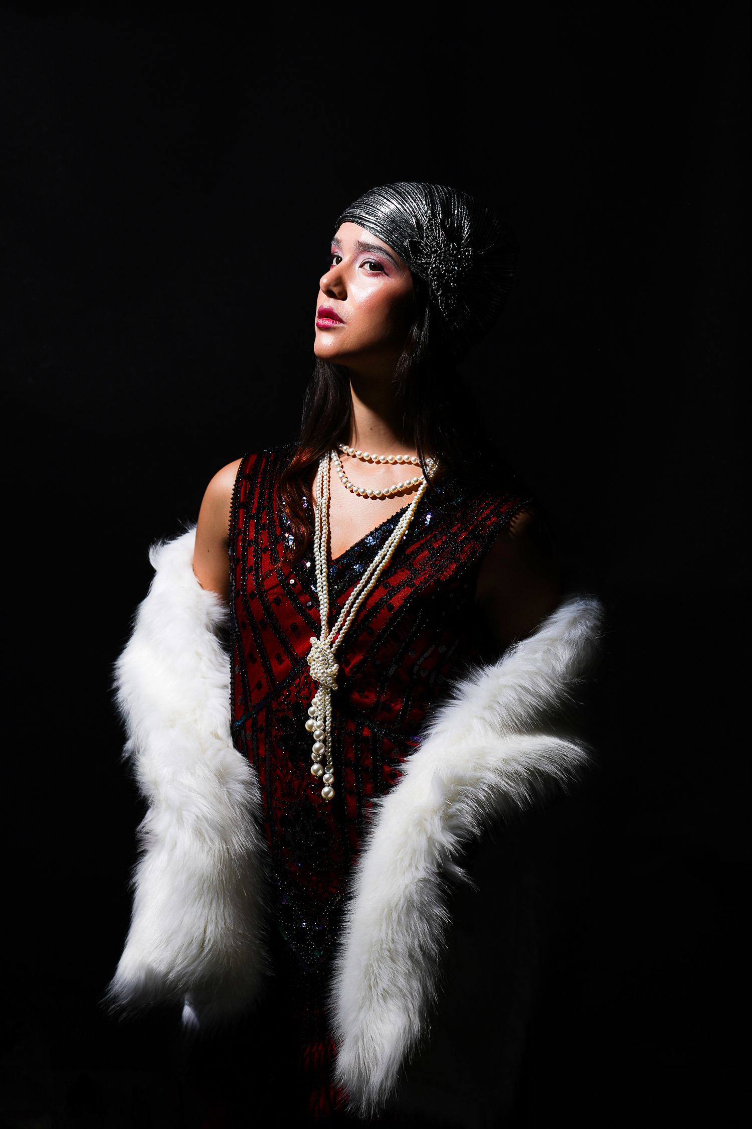 Girl in a flapper outfit and dark backdrop