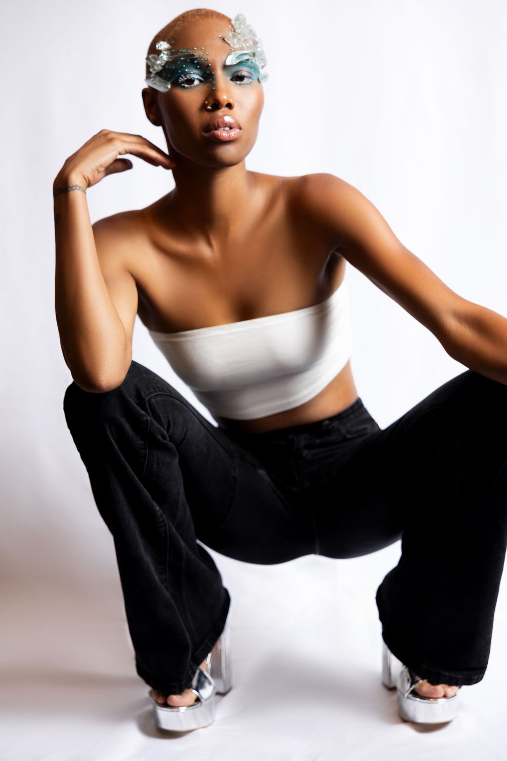 Modern fashion portrait with crystal glass eye makeup, white top and black pants.