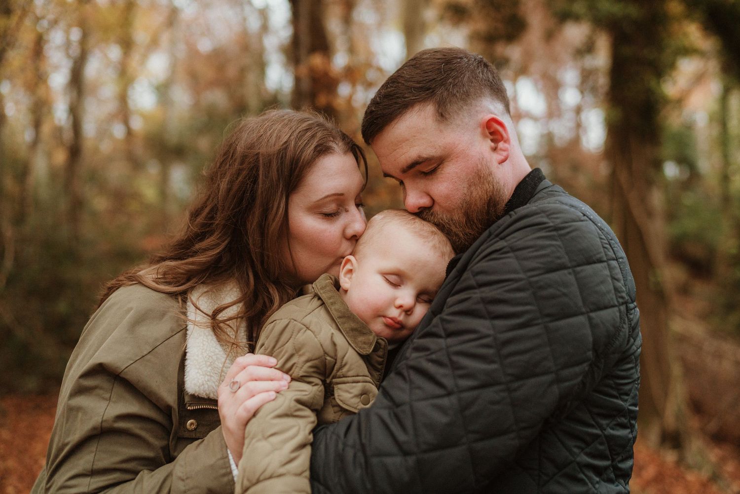 Intimate autumn family portrait session in a wooded setting.
