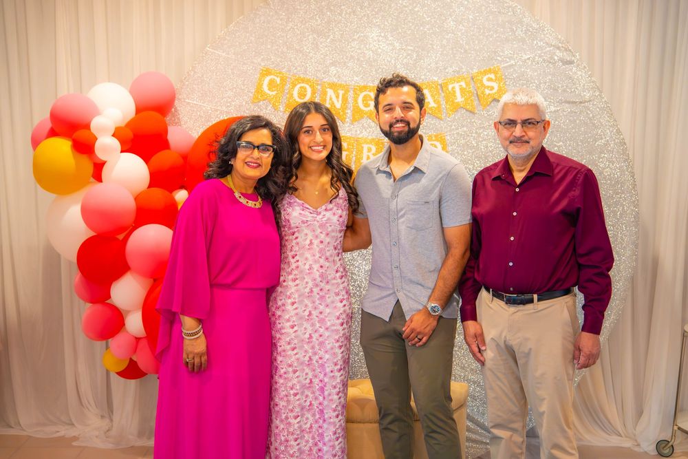 Party decorations including red and white balloons and gold lettering against a white backdrop at a celebration event Quad Cities Graduation