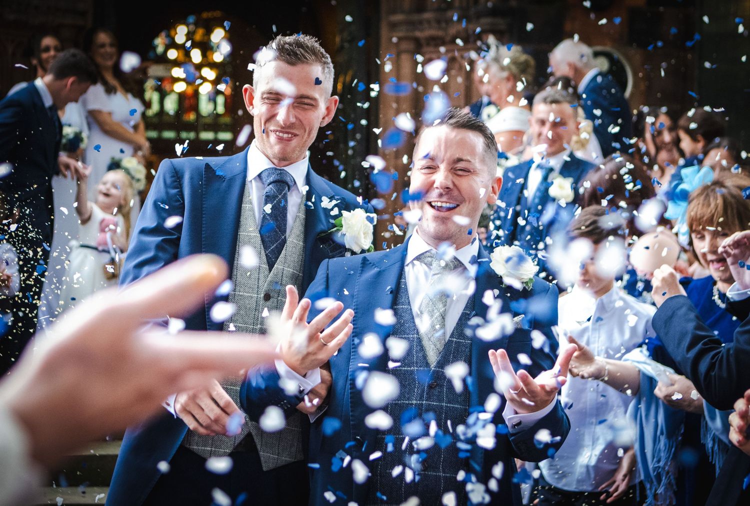 Wedding guests celebrate with confetti and champagne in a joyful outdoor reception.