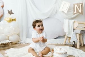 Servizio fotografico del primo compleanno con decorazioni e tema bianco.
