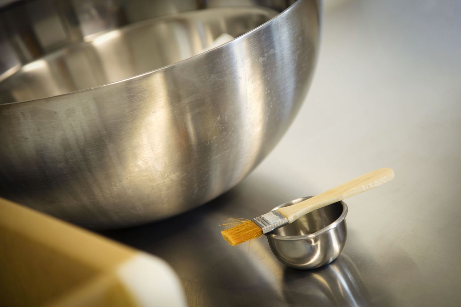 Bol à mélanger en acier inoxydable et outils de mesure sur un comptoir de cuisine.